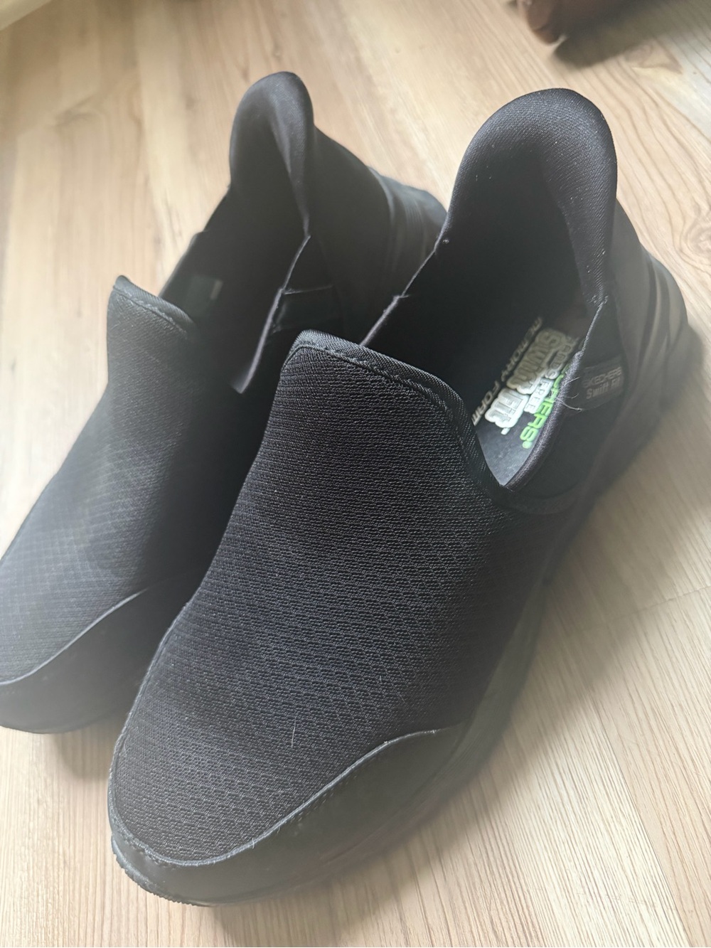 black Skechers Equalizer slip-on shoes featuring a breathable mesh upper and mem